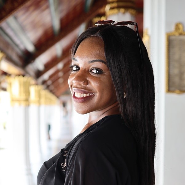 Woman with sunglasses on her head smiles.