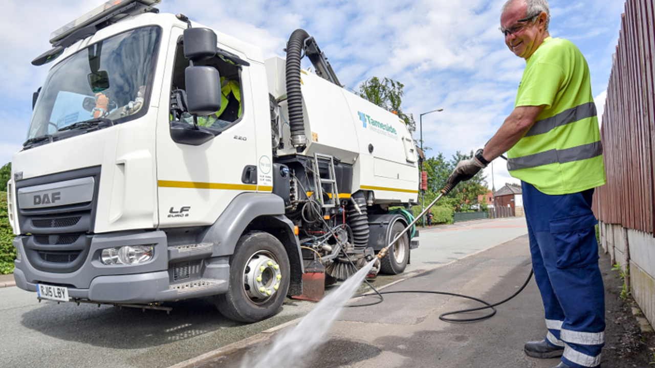 Man operating a road sweeper on the street.