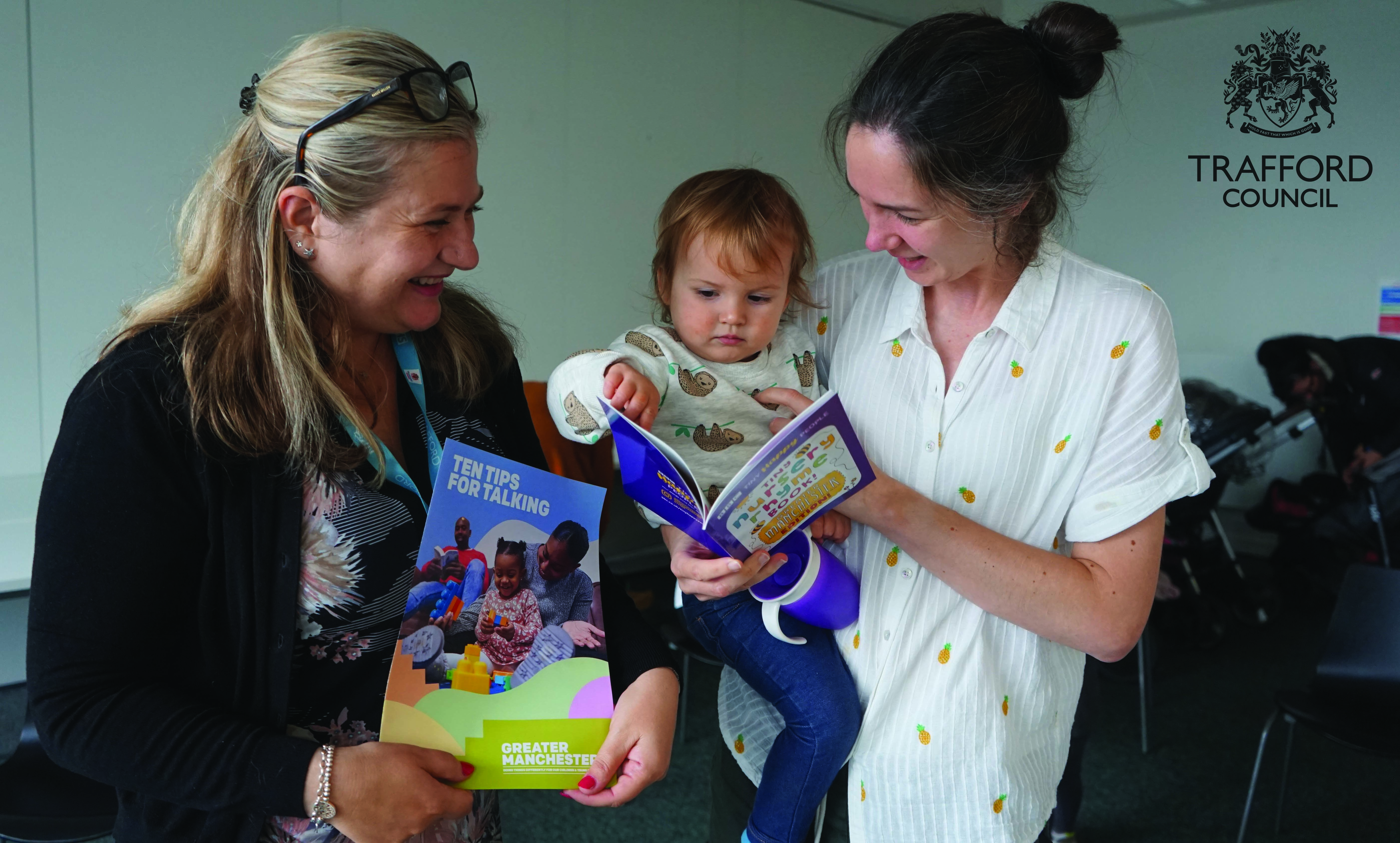 Woman reads to a child. Trafford Council logo.