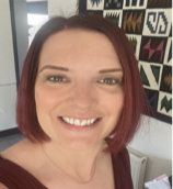 Woman with short red hair smiling at the camera.