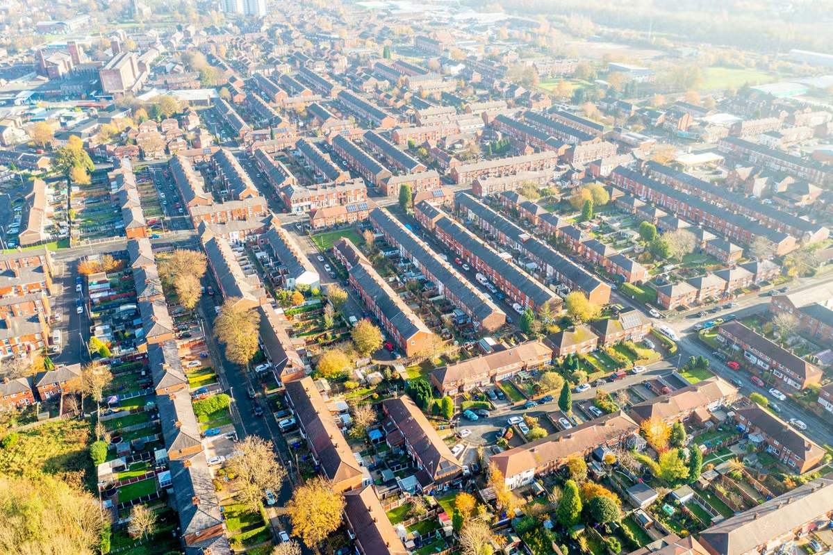 Aerial view of townhouses with trees, cars and streets.
