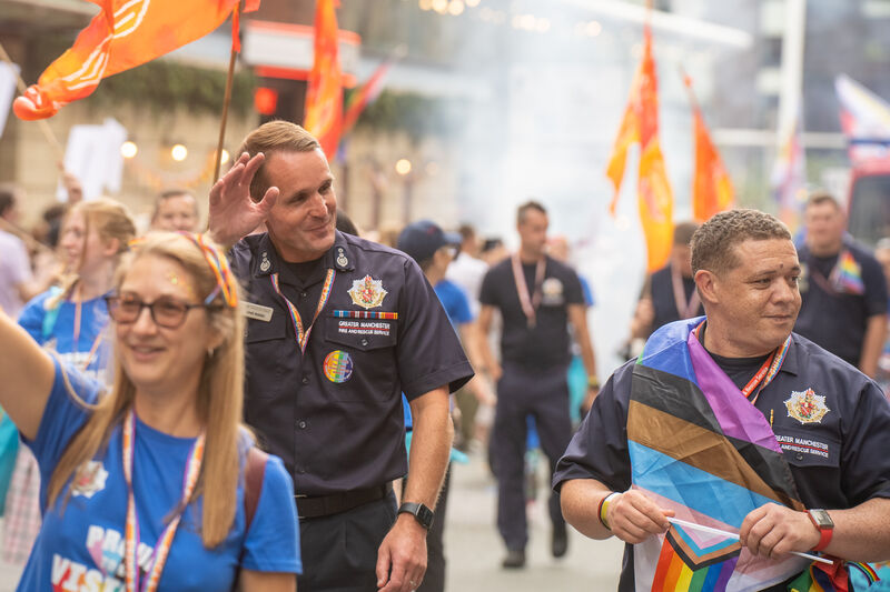 People at a parade with flags and uniforms.