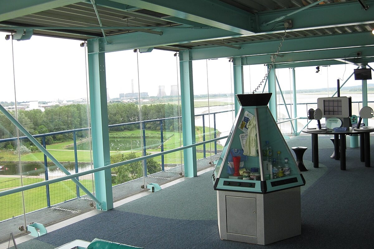 Interior of a building with a display case and large windows overlooking a lake.