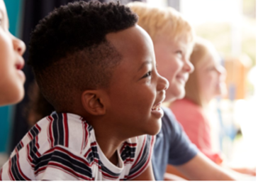Multi-ethnic children smiling, looking at something.