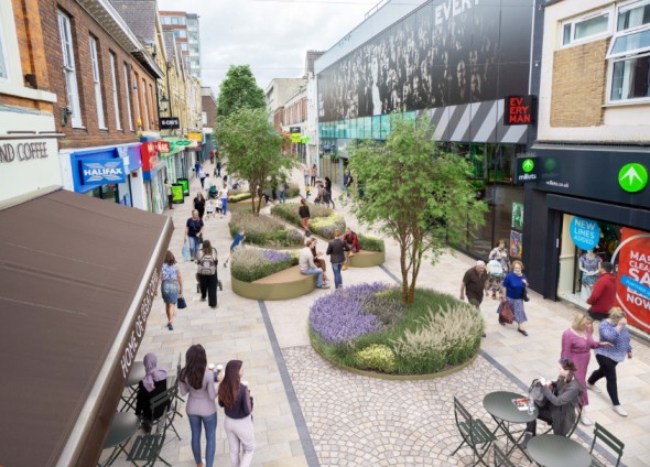 Pedestrianized street with shops, trees, and seating areas.