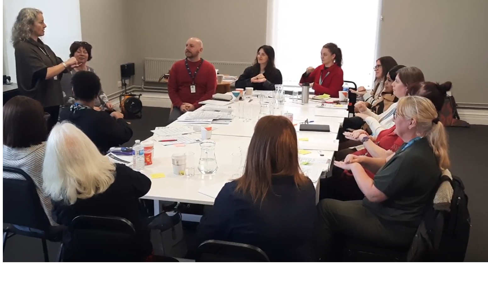 Group of people at a conference table, collaborative meeting.