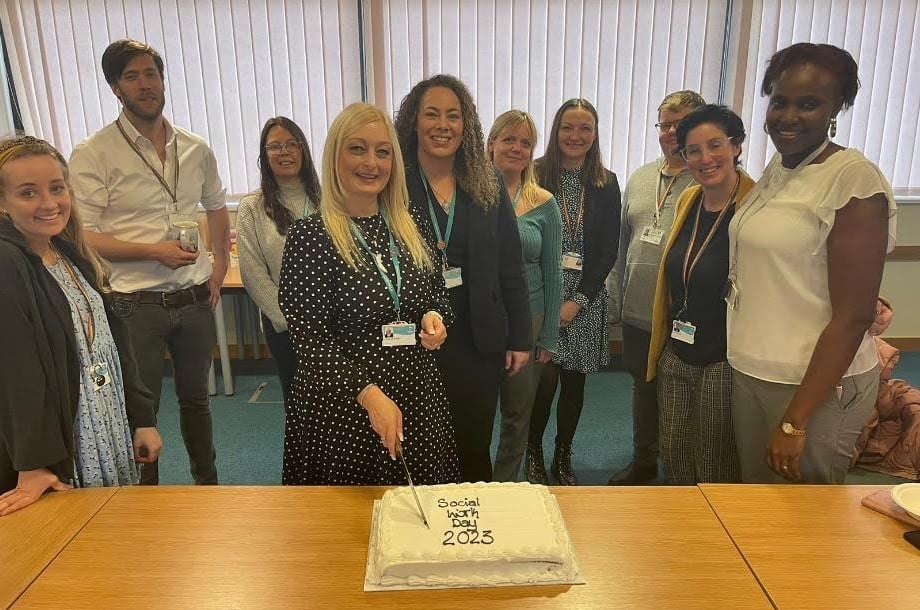 Group photo with cake celebrating Social Work Day 2023.
