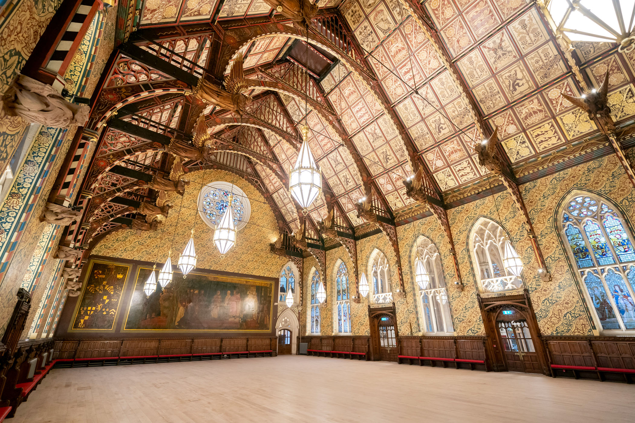Elaborate hall with high ceilings, chandeliers, and stained glass windows.