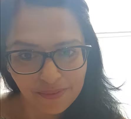 Portrait of a woman wearing glasses, smiling.