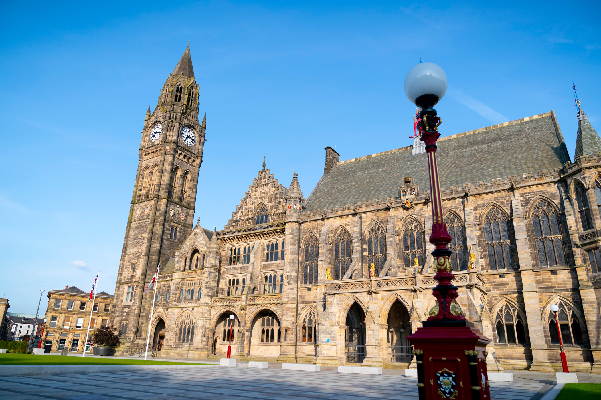 Town Hall with clock tower, blue sky, and a lamp post.